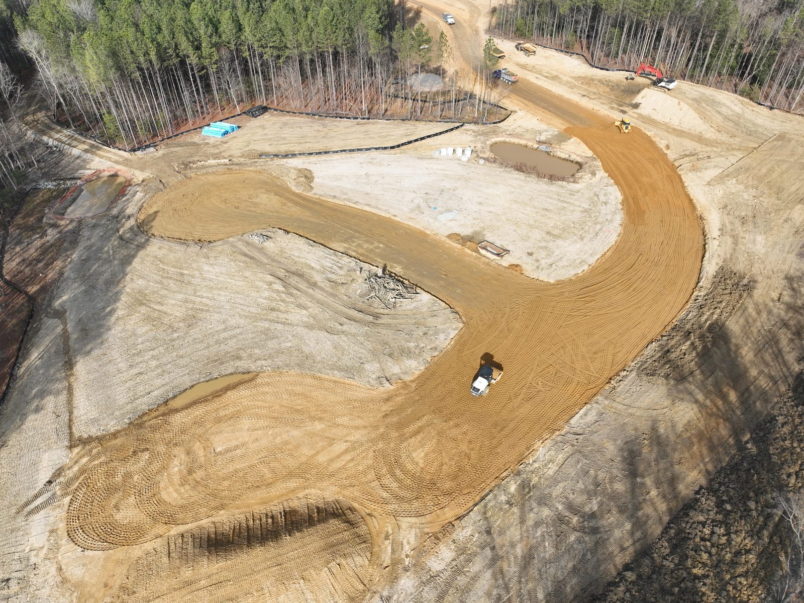 Aerial view of a Dorado land development site: graded earth, a new road, and sediment ponds carved from raw ground